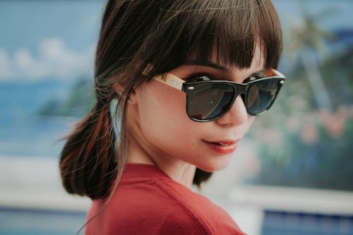 Free A Woman in Red Shirt Wearing Sunglasses Stock Photo