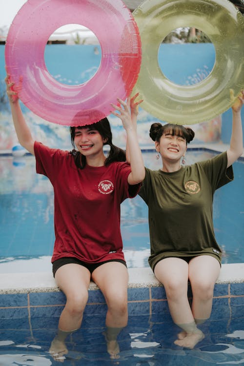 Free Teenage Girls Holding Floaters Beside Swimming Pool Stock Photo