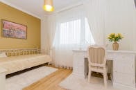 这间极简主义风格的卧室优雅大方，配有白色家具和温暖的装饰