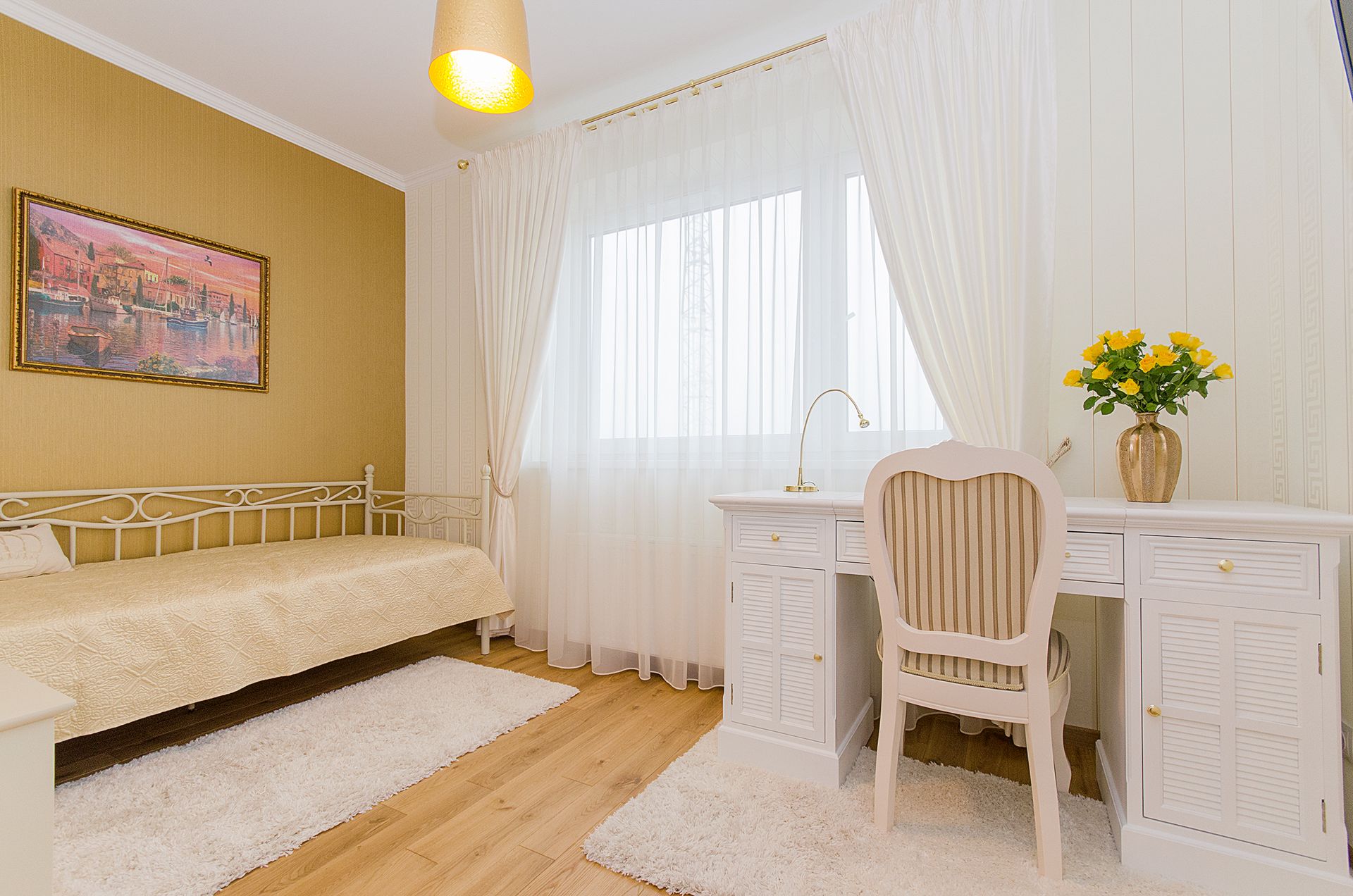Elegant minimalist bedroom with white furniture and warm decor accents.