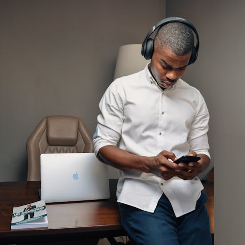 Man in White Top Using Cellphone