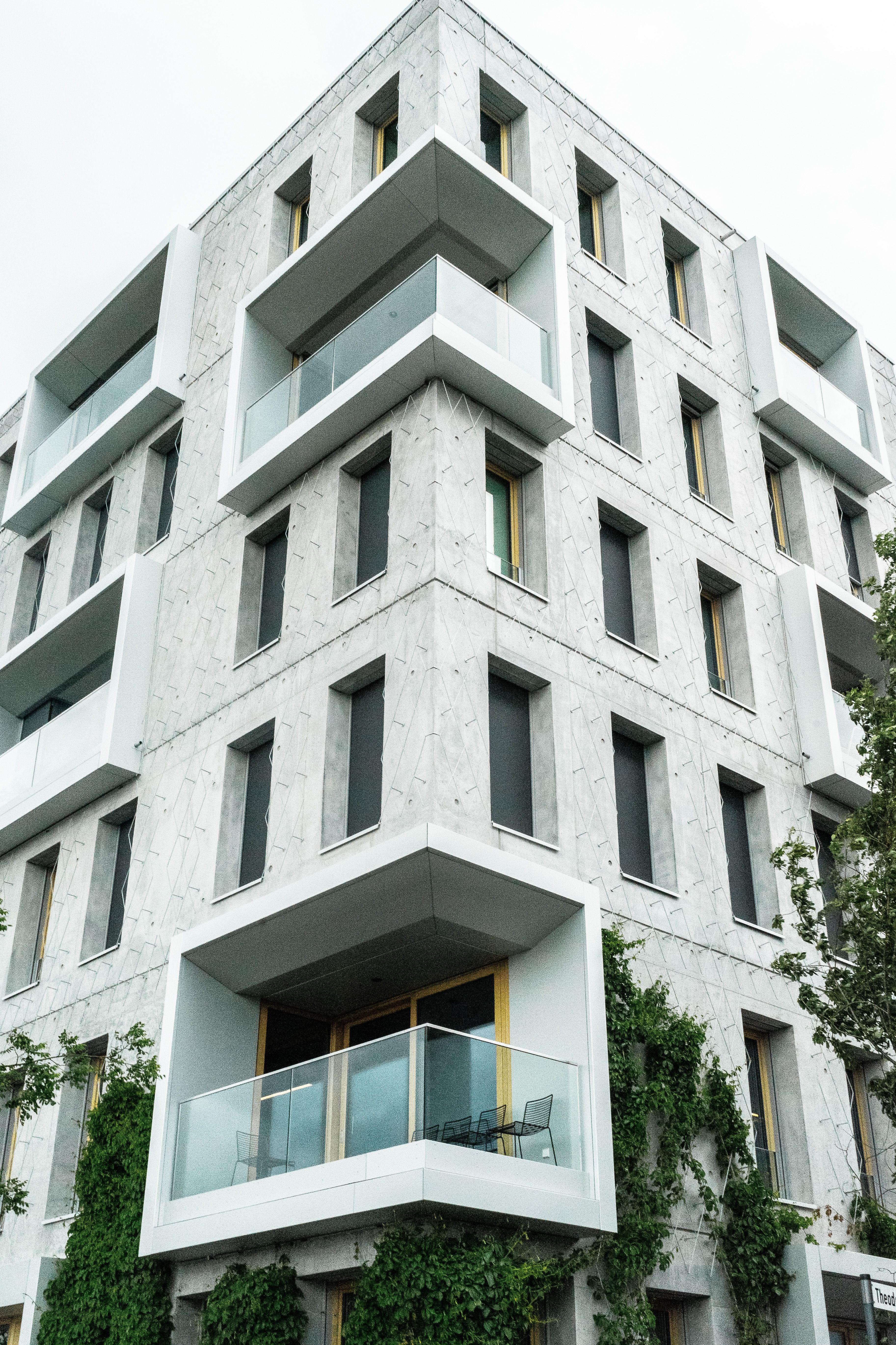 A modern apartment building with a green lawn · Free Stock Photo