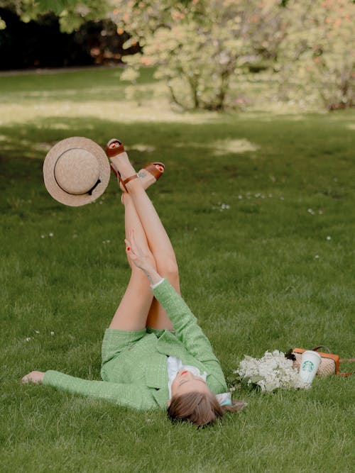 Foto profissional grátis de campo de grama, chapéu marrom, deitando-se