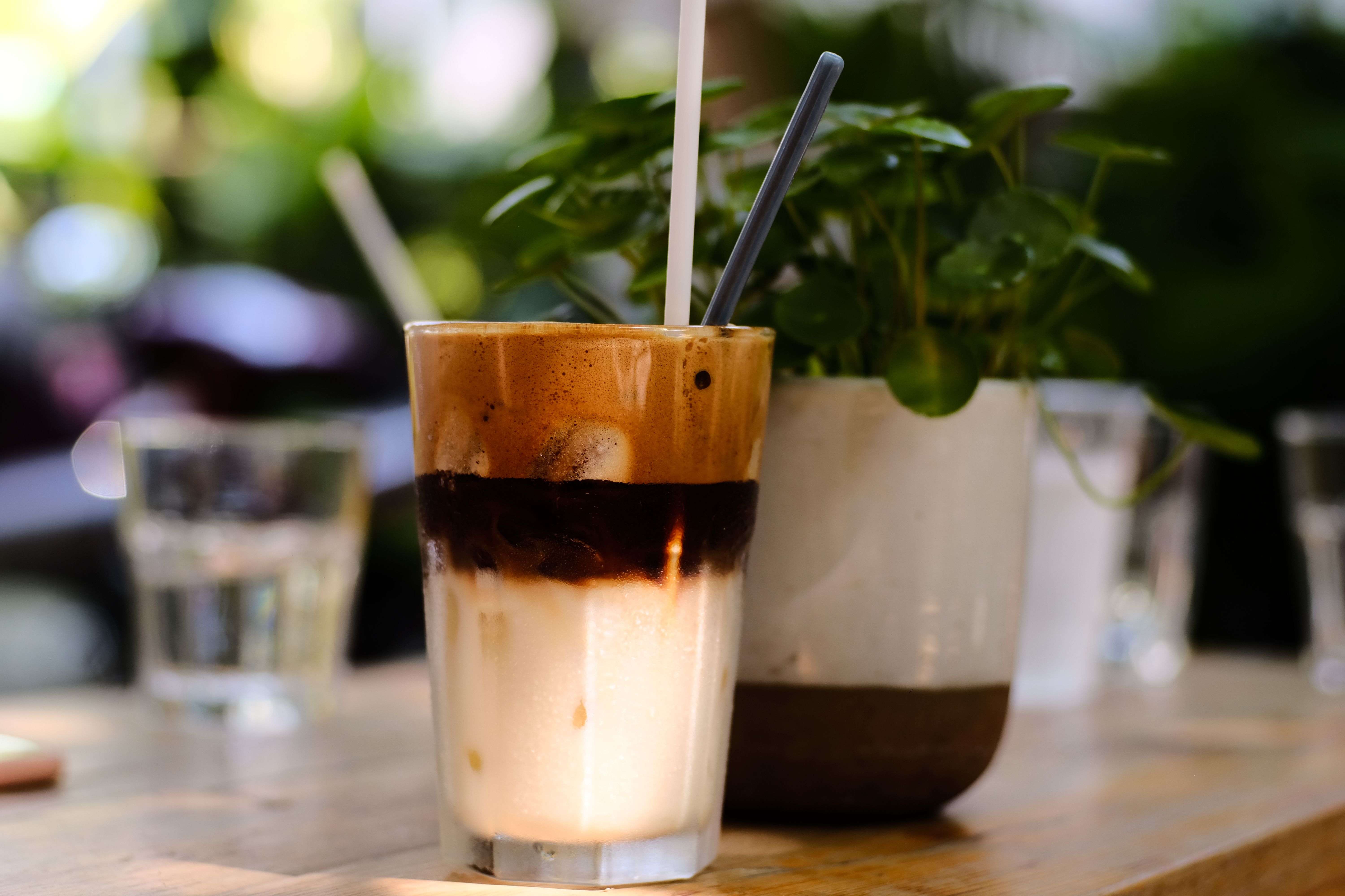 Close-up of a delicious iced coffee with straws, perfect for a sunny outdoor setting.