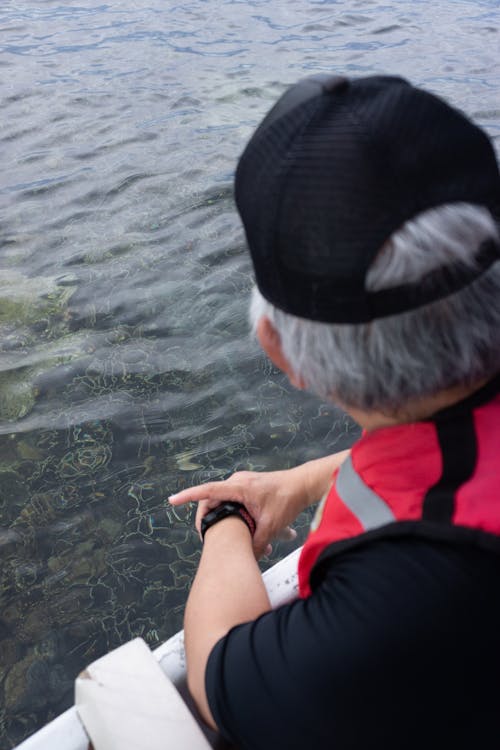 A Man Looking at the Clear Water of the Sea