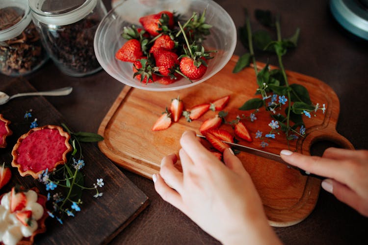 A Person Slicing Red Strawberries