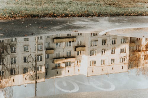 Reflection of Concrete Building on the Puddle of Water