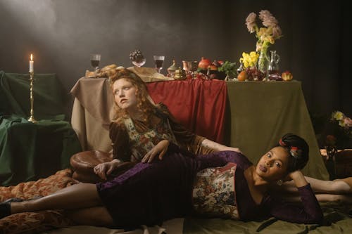 Women in Floral Dress Lying on the Floor Near the Feast Table