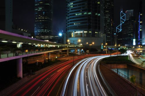 Free A captivating long exposure of a bustling city street at night with vibrant light trails. Stock Photo