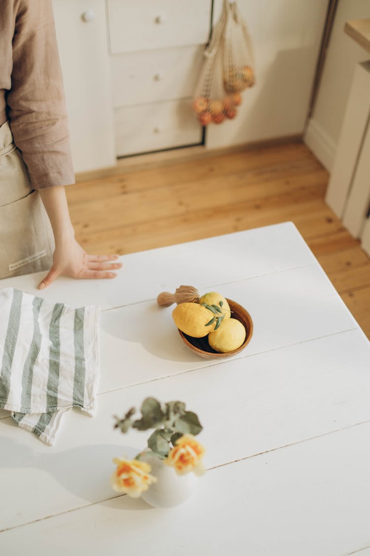 A Bowl Of Lemons On A Wooden Table 