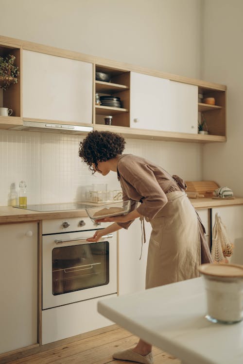 Free Woman Cooking in an Oven Stock Photo