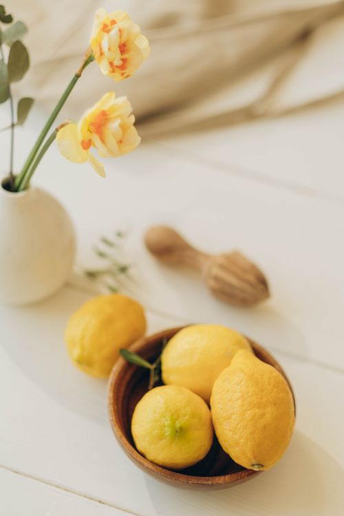 Free Elegant still life of lemons and flowers on a wooden surface with soft lighting. Stock Photo