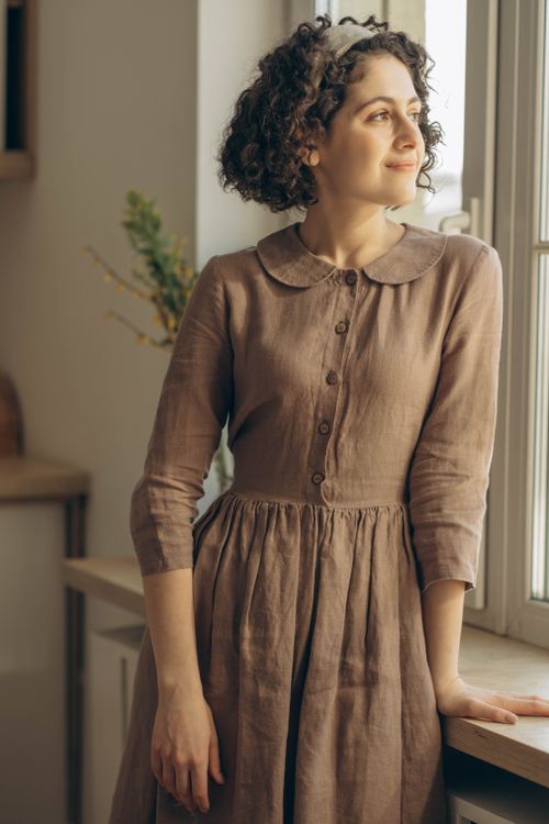 Woman in Brown Dress Standing Near the Glass Windows · Free Stock Photo