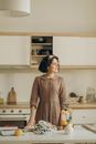 Woman in Brown Long Sleeve Dress Standing in Kitchen