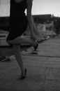 A Woman in Black Dress Fixing Her Heels