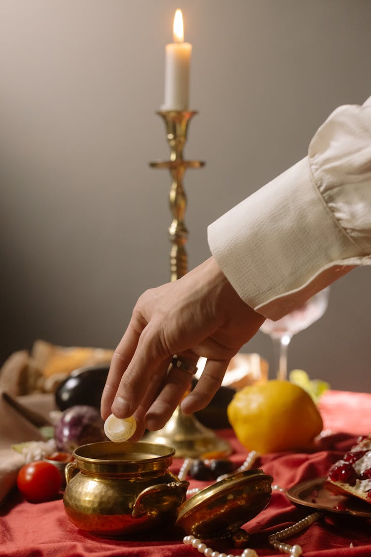 Person Picking Up Food In A Brass Bowl
