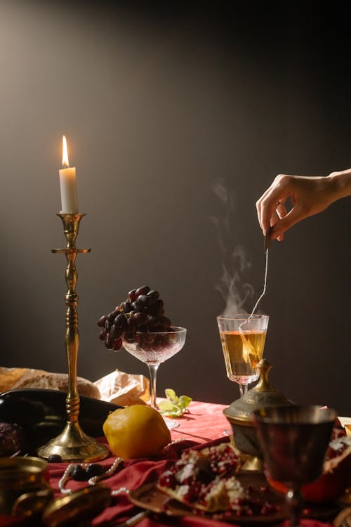 Free Person holding a Tea Bag submerged in a Wine Glass Stock Photo