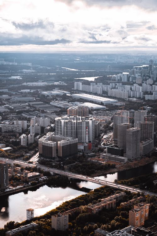 Free A captivating aerial shot of a sprawling urban cityscape with high-rise buildings and a river view. Stock Photo