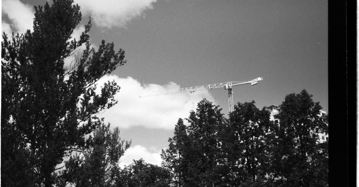 Construction cranes over a Toronto building site as CMHC forecasts slower housing construction