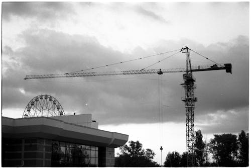 Grayscale Photo of a Crane Over the Building