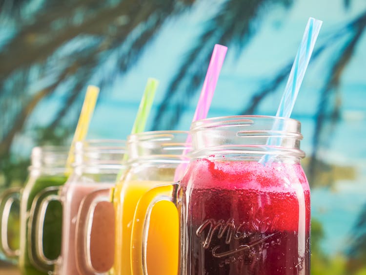 Close Up Photo Of Fruit Juices On Mason Jars