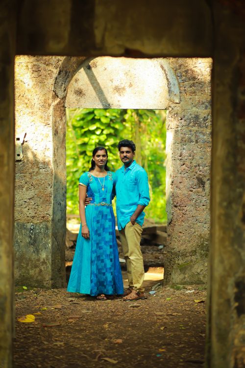 Free A couple standing together in a doorway outdoors, expressing love and affection. Stock Photo