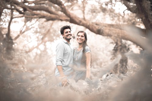 Free A Couple Smiling while Standing Together Stock Photo