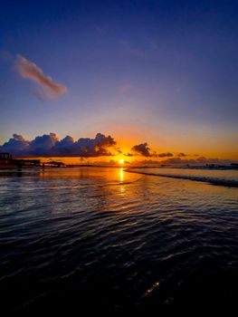 Vibrant sunset over ocean with dramatic clouds and serene waters inviting tranquility.