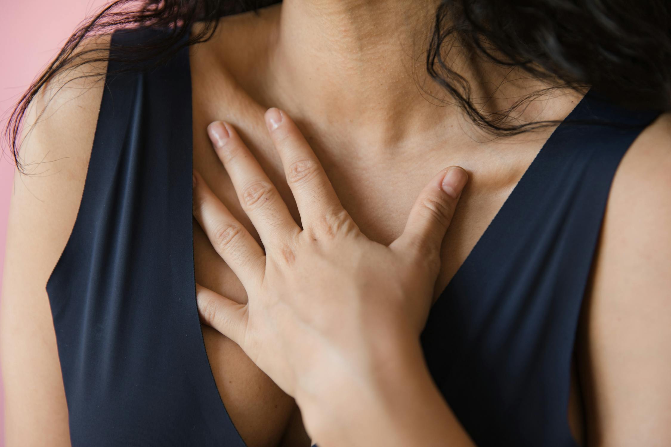 Woman in Blue Sleeveless Top with Hand on Chest