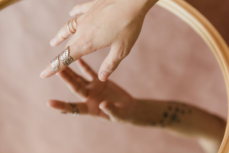 Hand Of A Woman Touching A Mirror