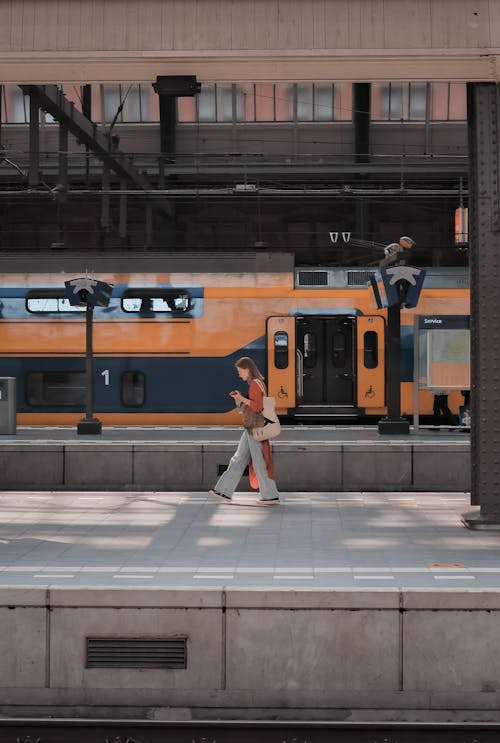 Young Woman Walking on a Platform at the Train Station 