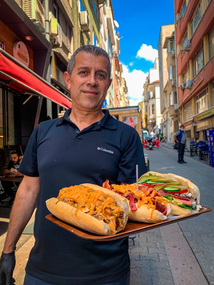 Man Carrying A Tray With Sandwiches