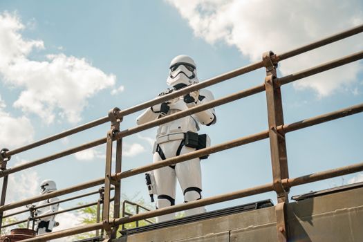 Stormtrooper standing on a platform against a clear blue sky with clouds.