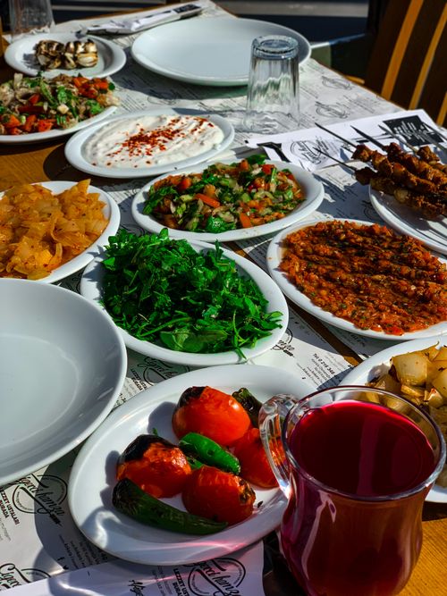 Free A vibrant Mediterranean meal displaying a variety of traditional dishes and fresh ingredients on a sunlit table. Stock Photo