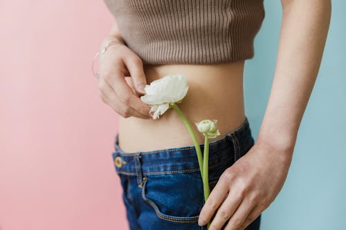 Gratis arkivbilde med blå dongeribukser, crop top, flora