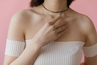 A Woman in White Off Shoulder Top with Her Hand on Her Chest