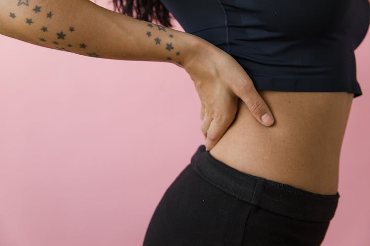 A Woman In Black Top Touching Her Back