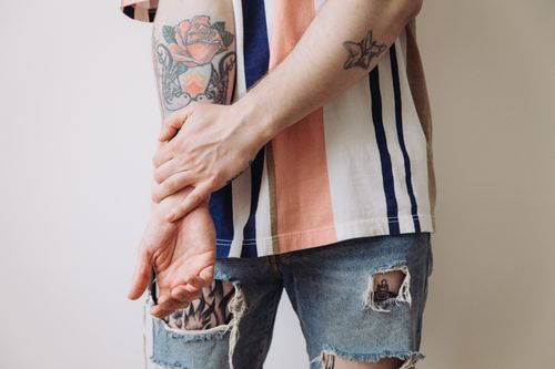 Free Detailed shot of tattooed arms in a striped shirt. Casual and stylish fashion. Stock Photo