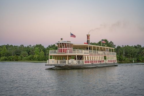 Free Charming riverboat cruise through a tranquil river at sunset, showcasing nature and Americana. Stock Photo