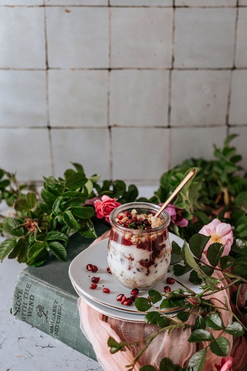 Yogurt with Granola in a Glass Standing on a Plate 