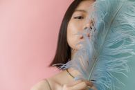 Close-up Photo of Woman holding Feathers