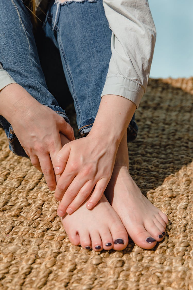 A Sitting Woman Holding Her Feet