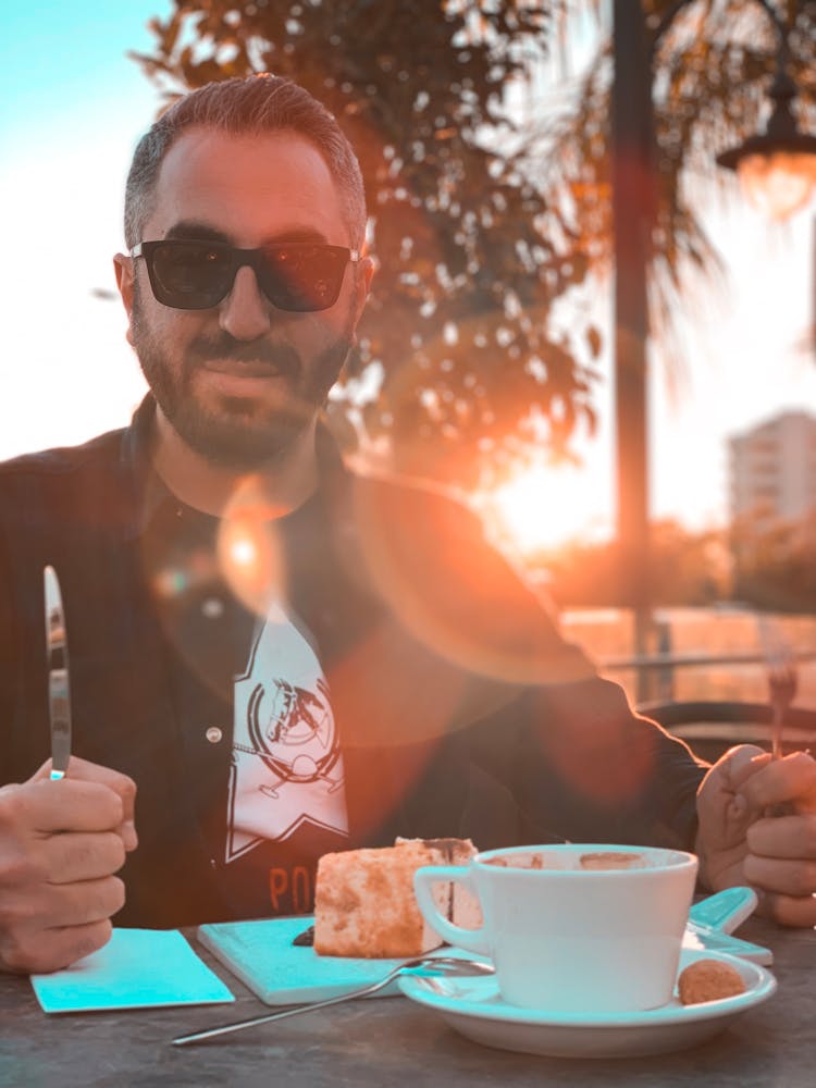 A Man In Black Sunglasses Holding A Knife And Fork