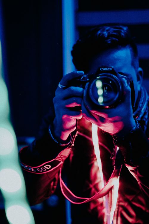 Free A photographer captures a moment with LED lights, creating a vibrant urban scene. Stock Photo