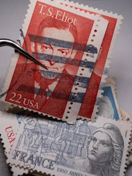 Close-up of vintage postage stamps including a 22 USA T.S. Eliot stamp.