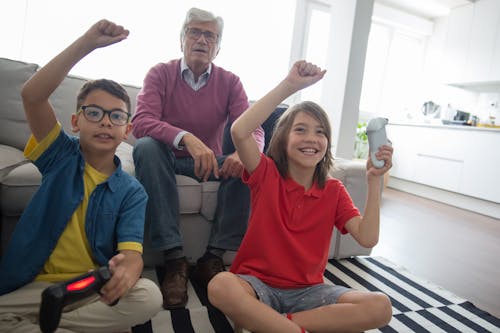Grandfather Looking at Grandsons Playing Video Games