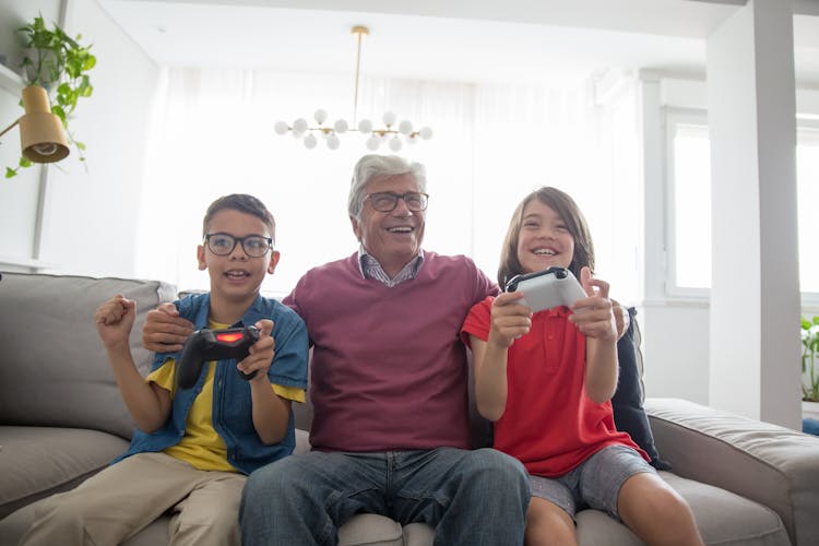 An Elderly Man Sitting Between His Grandchildren