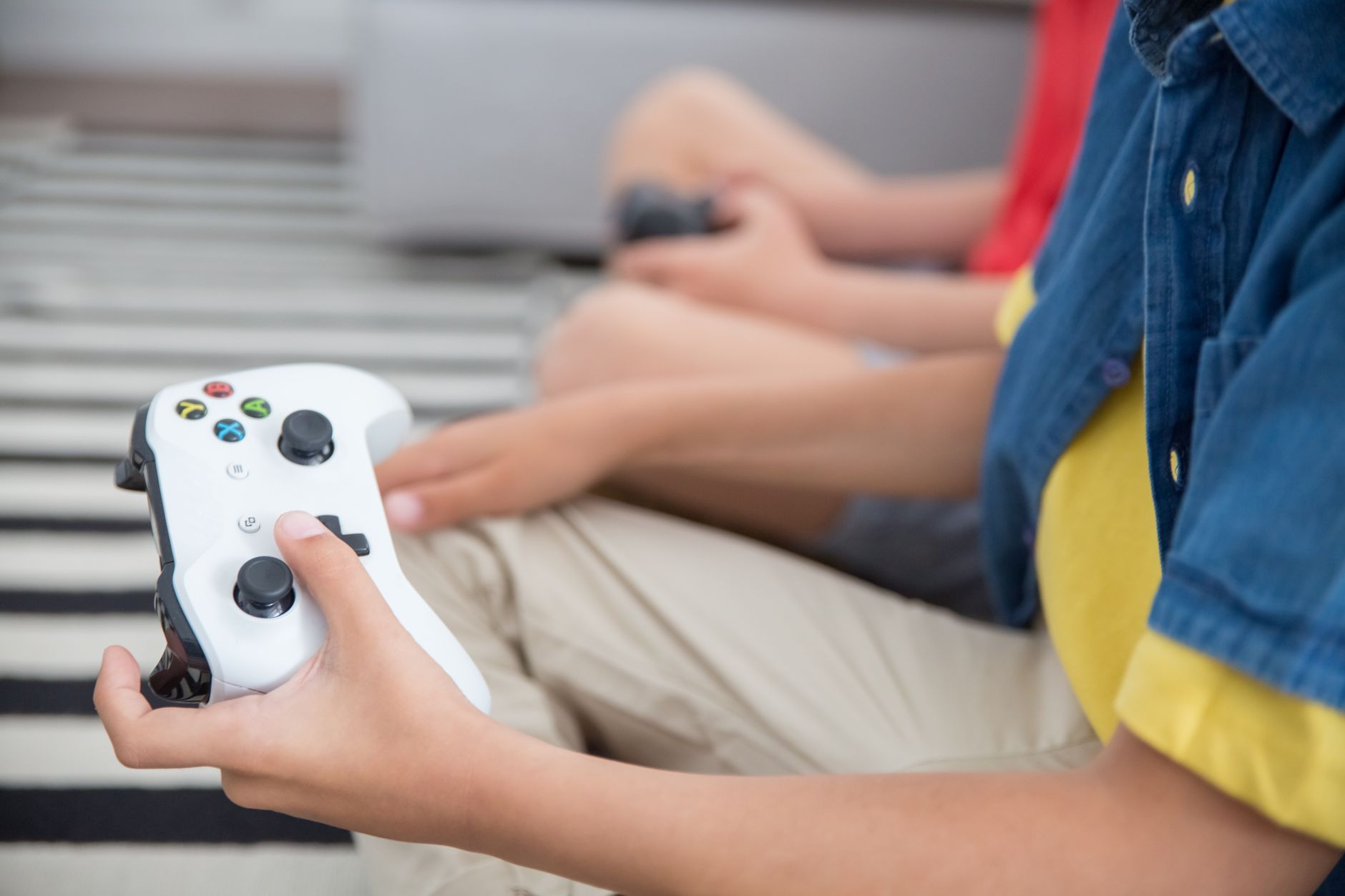 Two children playing video games with controllers, indoors, showcasing fun and technology.
