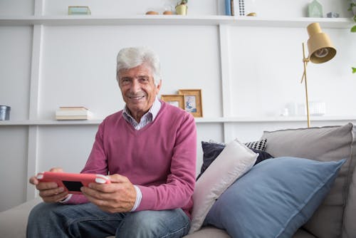 An Elderly Man Playing a Game Console