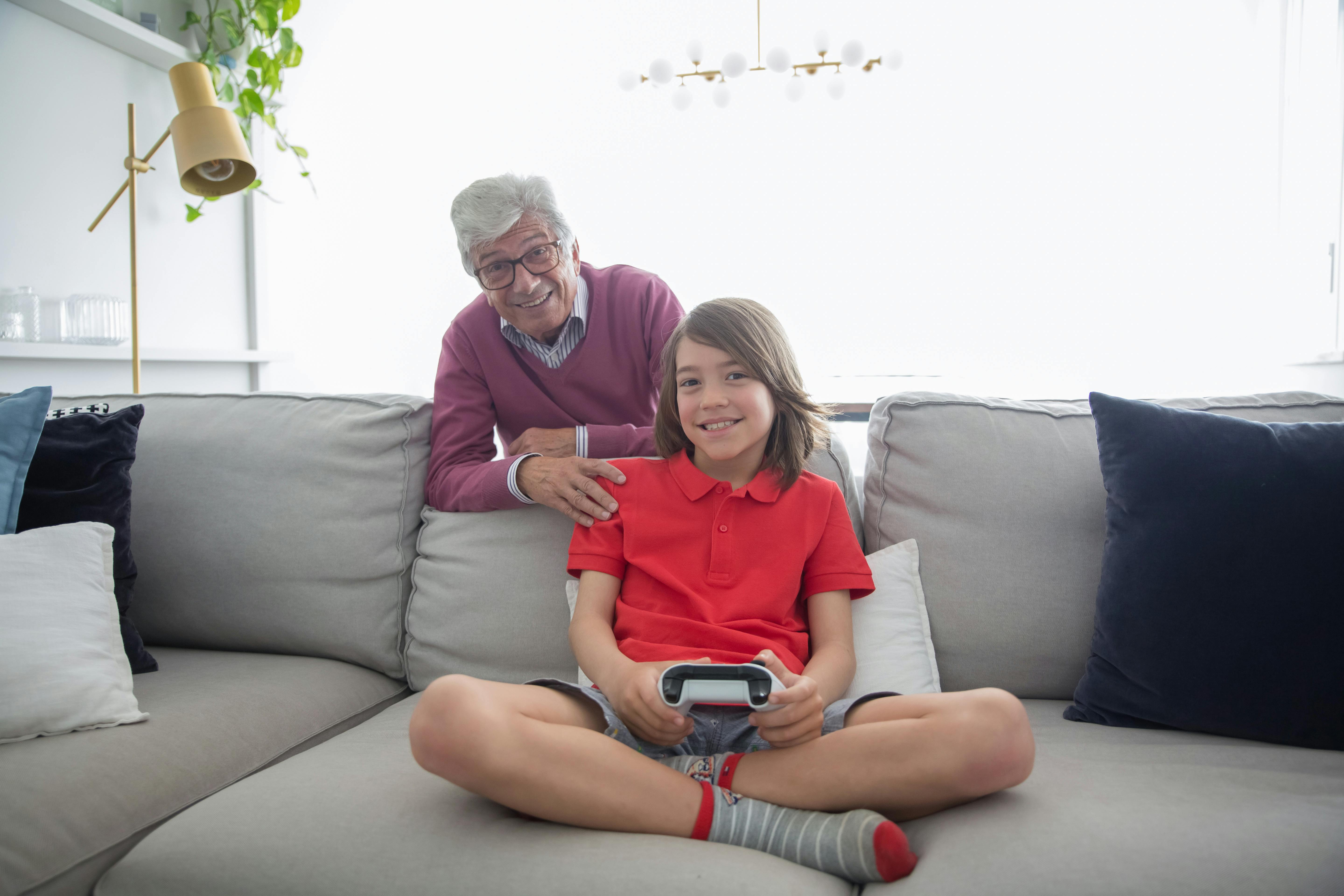 man and child sitting on gray couch